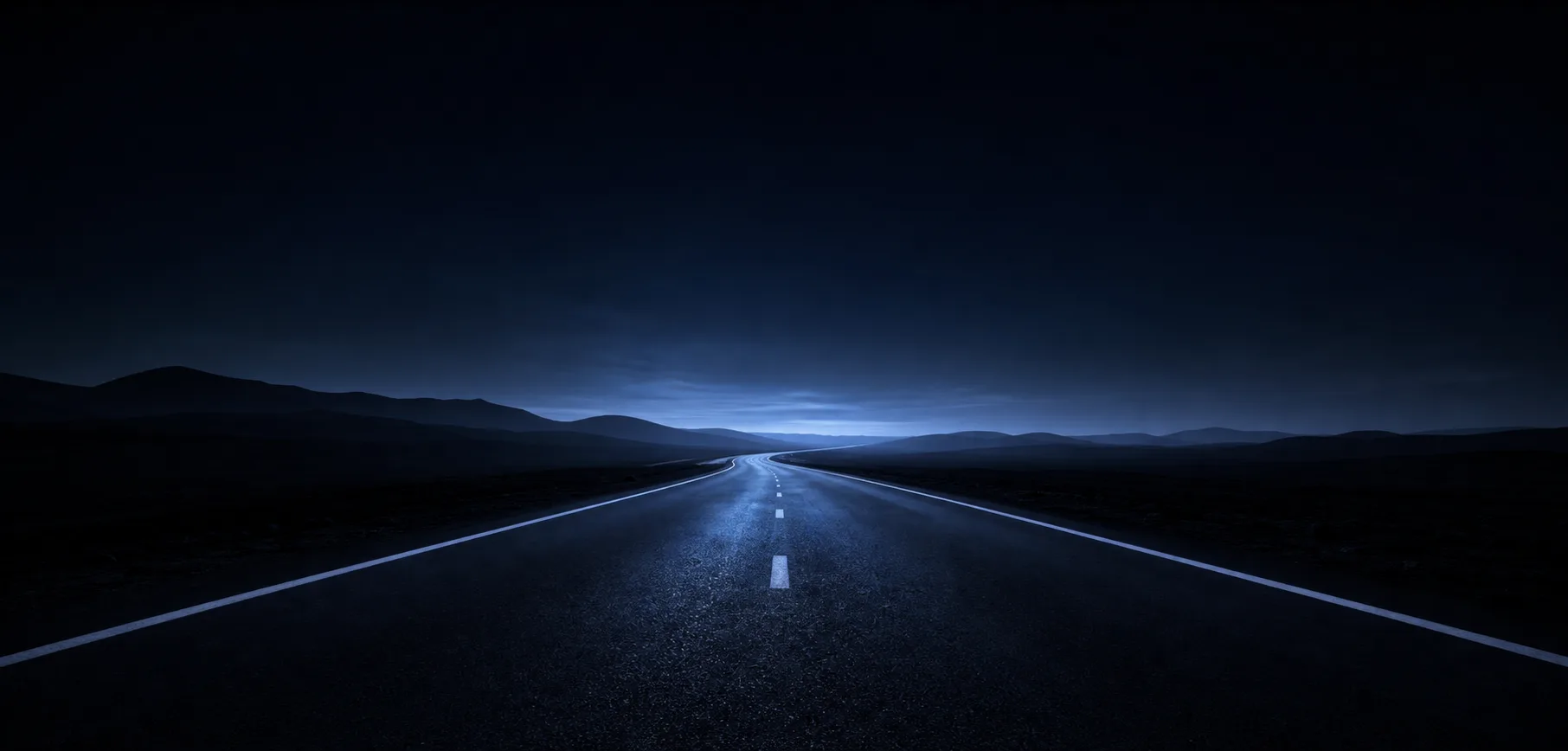A calm night road opening toward the horizon
